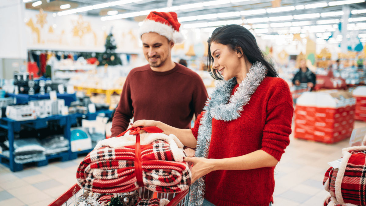 A couple wearing Christmas clothing doing their Christmas retail shopping